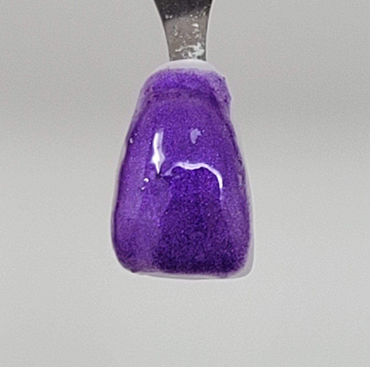 Deep Purple Temporary Tattooth Colorant on a demo tooth.  These colorants can be applied to teeth to temporarily alter their color or iridescence.