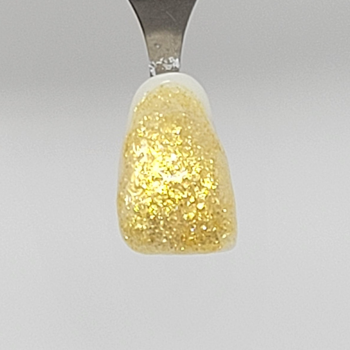 Gold Sparkle Temporary Tattooth Colorant on a demo tooth.  These colorants can be applied to teeth to temporarily alter their color or iridescence.