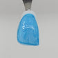 Light blue Temporary Tattooth Colorant on a demo tooth.  These colorants can be applied to teeth to temporarily alter their color or iridescence.