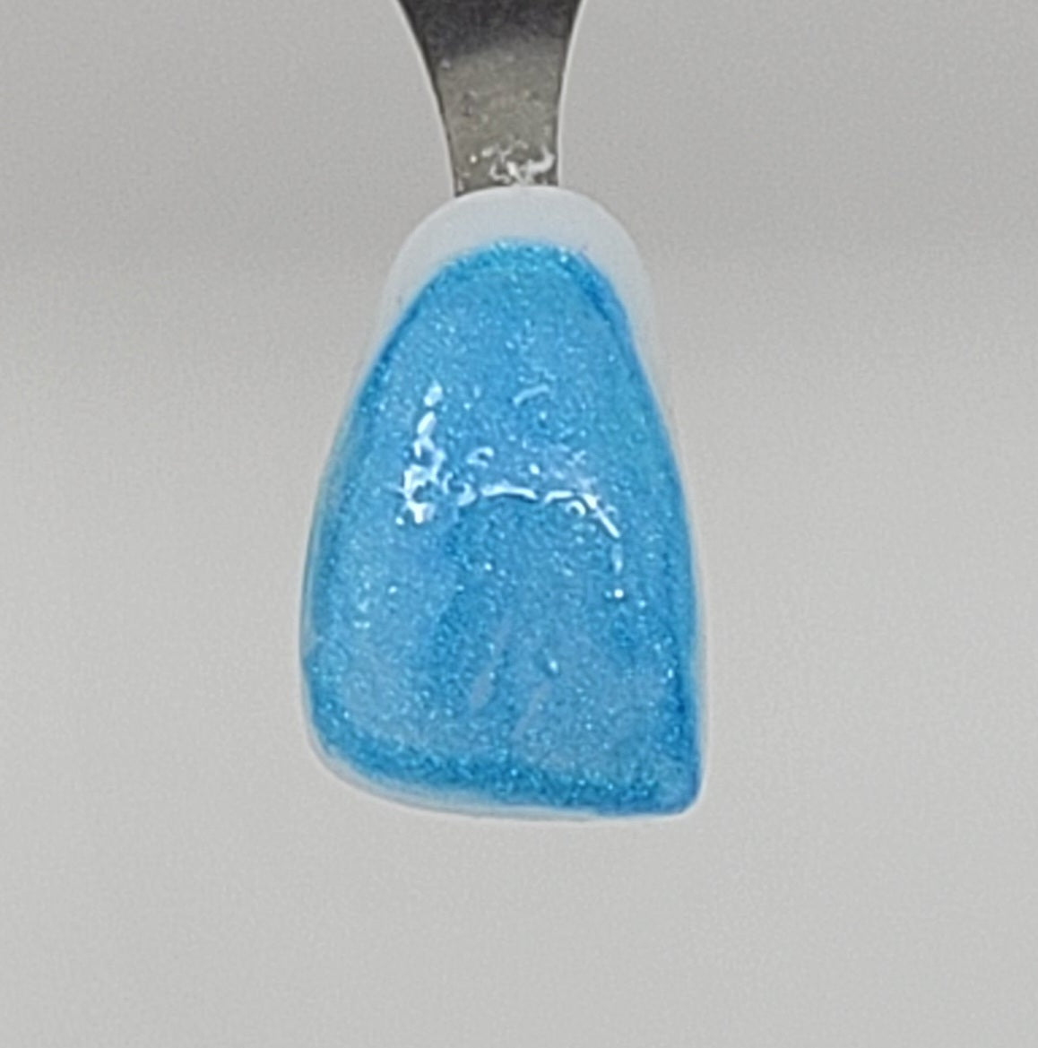 Light blue Temporary Tattooth Colorant on a demo tooth.  These colorants can be applied to teeth to temporarily alter their color or iridescence.
