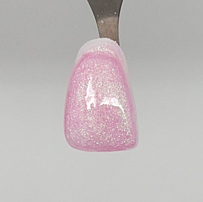 Pink Lime Opal Temporary Tattooth Colorant on a demo tooth.  These colorants can be applied to teeth to temporarily alter their color or iridescence.