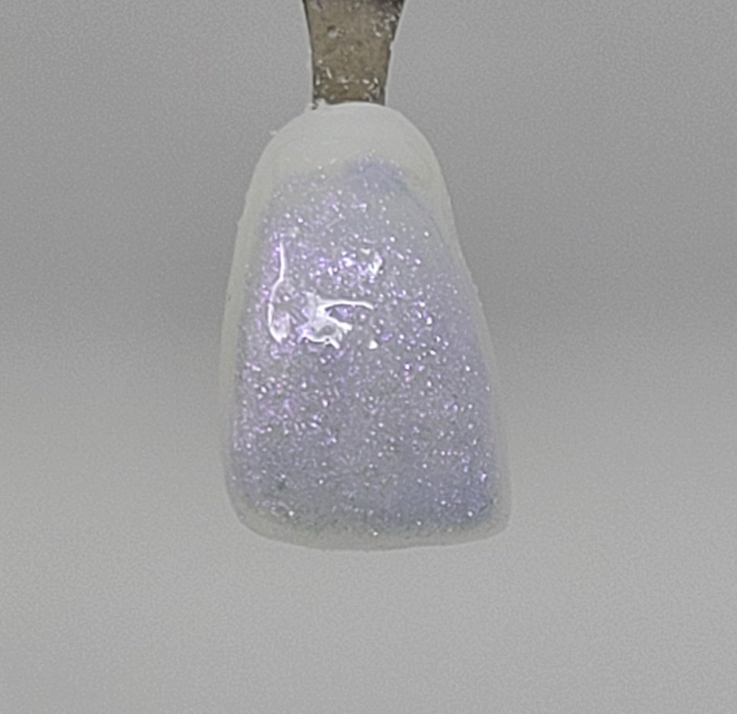 Violet Opal Temporary Tattooth Colorant on a demo tooth.  These colorants can be applied to teeth to temporarily alter their color or iridescence.